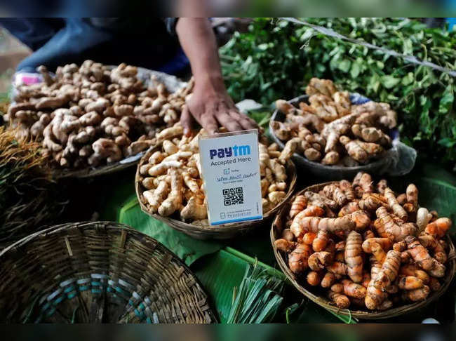 FILE PHOTO: An advertisement board displaying a QR code for Paytm, a digital wallet company, is seen placed amidst vegetables at a roadside vendor's stall in Mumbai