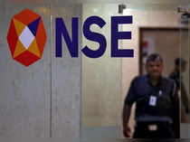 FILE PHOTO: A security guard walks past the logo of the National Stock Exchange inside its building in Mumbai