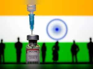 3D-printed small toy figurines, a syringe and vial labelled "coronavirus disease (COVID-19) vaccine" are seen in front of India flag in this illustration