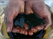 FILE PHOTO: An employee demonstrates a sample of crude oil in the Irkutsk Oil Company-owned Yarakta Oil Field in Irkutsk Region