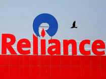 FILE PHOTO: A bird flies past a Reliance Industries logo installed on its mart in Ahmedabad