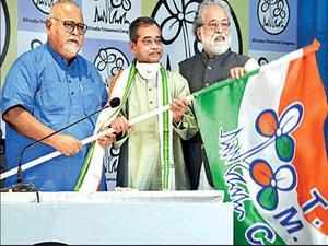 Abhijit Mukherjee (centre) is handed over the Trinamool flag by Partha Chatterjee (left) in the presence of Sudip Bandyopadhyay at Trinamool Bhavan on Monday