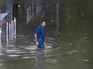 Mumbai: A man wades through a waterlogged street at Parel after heavy rains in M...