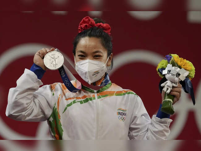 Mirabai Chanu poses for photographs while standing on the podium ...