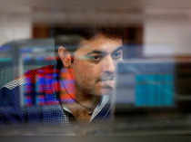 FILE PHOTO: A broker reacts while trading at his computer terminal at a stock brokerage firm in Mumbai