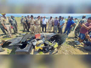 Kathua: Police personnel inspect the site after a helicopter of the Indian Army ...