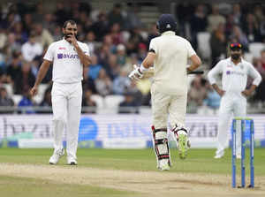 Leeds: India's Mohammed Shami, left, reacts after England captain Joe Root, cent...