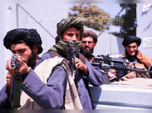 Taliban forces stand guard in front of Hamid Karzai International Airport in Kabul