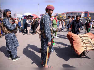 Taliban security forces stand guard among crowds of people in a street in Kabul
