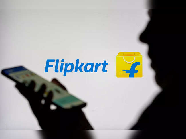 FILE PHOTO: Woman with smartphone is seen in front of displayed Flipkart logo in this illustration taken