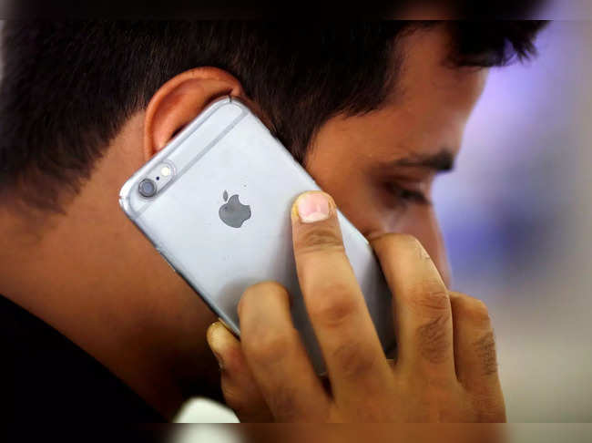 FILE PHOTO: A man talks on his iPhone at a mobile phone store in New Delhi