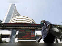 A man wearing a protective mask walks past the Bombay Stock Exchange (BSE) building in Mumbai