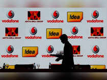 FILE PHOTO: A hotel employee clears a table after Vodafone Group and Idea Cellular news conference in Mumbai