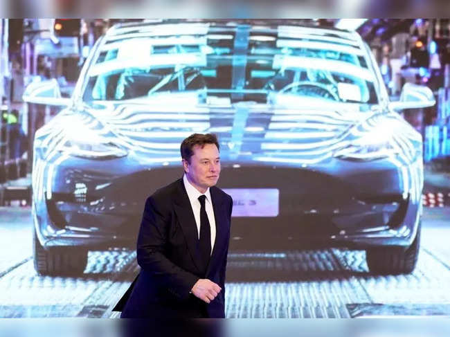 FILE PHOTO: Tesla Inc CEO Elon Musk walks next to a screen showing an image of Tesla Model 3 car during an opening ceremony for Tesla China-made Model Y program in Shanghai