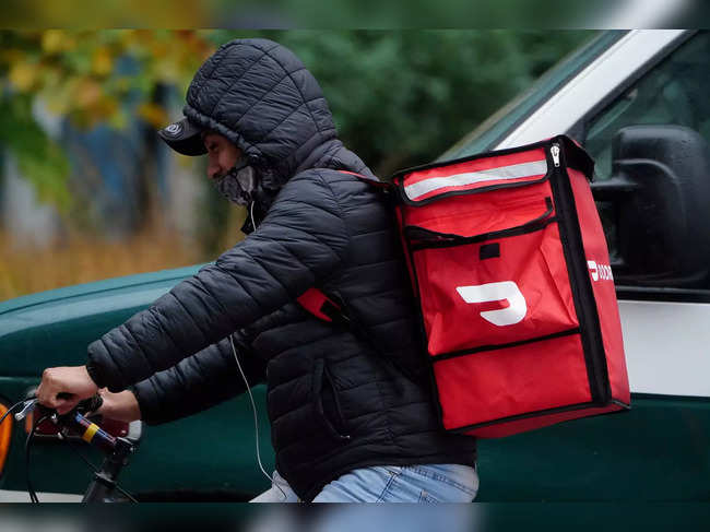 FILE PHOTO: A delivery person for Doordash rides his bike in the rain during the coronavirus disease (COVID-19) pandemic in the Manhattan borough of New York City
