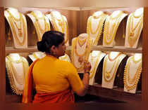 FILE PHOTO: FILE PHOTO: A saleswoman picks gold necklaces to show it to a customer inside a jewellery showroom on the occasion of Akshaya Tritiya, a major gold buying festival, in Kochi