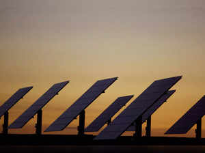 FILE PHOTO: The sun sets beyond solar panels at a power plant in Amareleja