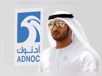 FILE PHOTO: An Emirati man is seen near the logo of  ADNOC in Ruwais