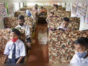 Mumbai: A social worker Ashok Kurmi teaches slum children in a school bus conver...
