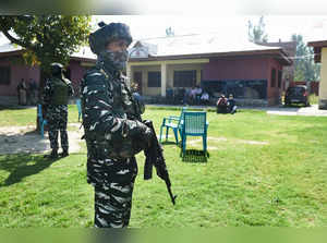 Security personnel stand guard at Government Boys Higher Secondary Sch...