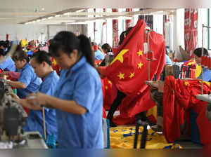 FILE PHOTO: Workers make Chinese flags at a factory ahead of the 70th founding anniversary of People's Republic of China, in Jiaxing, Zhejiang