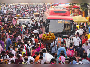 A man carrying flower garlands walks through a crowded market ahead of the religious festival of Dussehra, amidst the spread of the coronavirus disease (COVID-19) in Mumbai