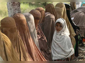 Peshawar: Women wait their turn to receive cash vouchers from an officer under t...