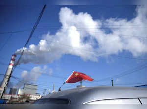 FILE PHOTO: A Chinese flag is seen on the top of a car near a coal-fired power plant in Harbin