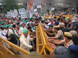 Noida: Police try to stop the farmers from breaking the barricade during their p...