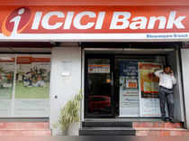 FILE PHOTO: A man speaks on the phone outside an ICICI Bank branch in Kolkata