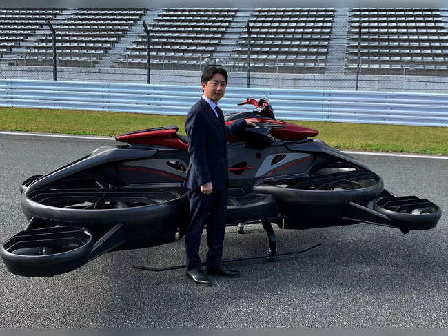 Japanese startup A.L.I. Technologies' Chief Executive Daisuke Katano poses next to its "XTurismo Limited Edition" hoverbike during its demonstration at Fuji Speedway in Oyama, Shizuoka Prefecture, Japan.