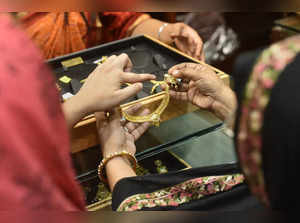 New Delhi: Women check gold ornaments before buying at a jewellery showroom on t...