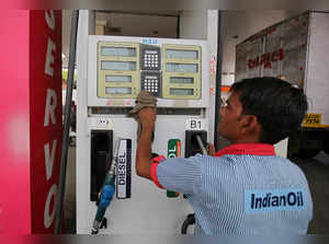 A worker cleans a pump at a fuel station in Ahmedabad