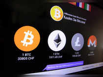 FILE PHOTO: Exchange rates and logos of Bitcoin, Ether, Litecoin and Monero are seen on a cryptocurrency ATM in Zurich
