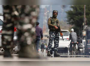 Indian Central Reserve Police Force personnel stand guard on a street, in Srinagar