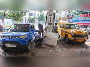 Kolkata: A pump attendent writes the petrol price on a board as diesel and petro...