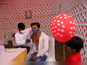 A health worker administers a dose of a vaccine for the coronavirus disease (COVID-19) at a vaccination center setup during the religious festival of Chhath Puja in New Delhi
