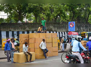Labourers with boxes wait for transportaion