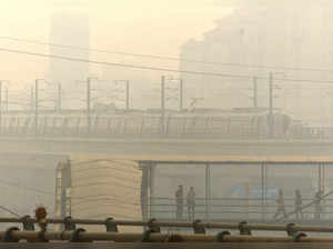 Gurugram: A metro train makes its way amid low visibility due to a thick layer o...