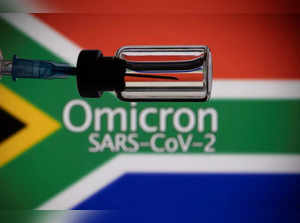 A vial and a syringe are seen in front of a displayed South Africa flag and words "Omicron SARS-CoV-2" in this illustration taken