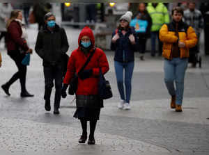 A woman wearing a face mask walks through the centre of Liverpool