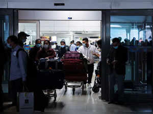 People exit from the arrival section of the Indira Gandhi International Airport in New Delhi