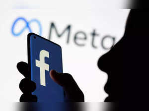 FILE PHOTO_ Woman holds smartphone with Facebook logo in front of Facebook's new rebrand logo Meta in this illustration picture.