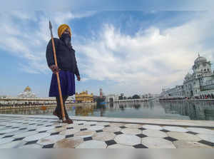 Amritsar: A Sikh guard stands holding a spear as devotees arrive to worship at t...
