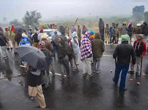 Farmers assemble on a road to block Prime Minister Narendra Modi's ca...