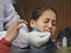 Kullu: A health worker collects a swab sample of a woman for COVID-19 test, at t...