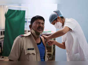 A policeman reacts as he receives a booster dose of the COVISHIELD vaccine manufactured by Serum Institute of India, at a vaccination centre, in Mumbai