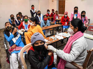 Patna: Health workers administer COVID-19 vaccine dose to students at a school, ...