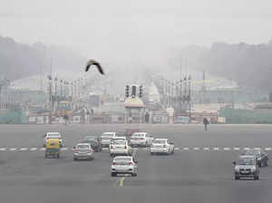 New Delhi: Vehicles ply at Rajpath amid low visibility due to fog, in New Delhi....