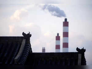 FILE PHOTO: Chimneys of a coal-fired power plant are seen behind a gate in Shanghai